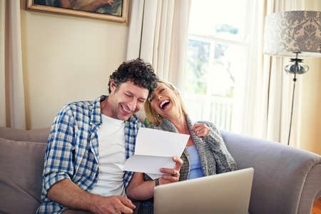 That was a laugh. a mature couple laughing while going over the expenses at home.