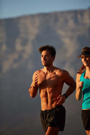 Running is an instant mood booster. an athletic young couple out for a run in the morning.の写真素材