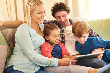Weekend entertainment gone digital. a family browsing together on a digital tablet at home.