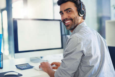 Im happy as long as my clients are happy. Portrait of a call centre agent working in an office.
