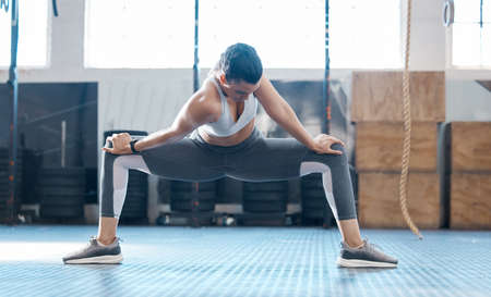 Gym, woman and stretching legs exercise before workout session training for injury prevention. Girl...