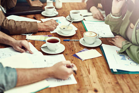 Working through some new business drafts. Closeup shot of businesspeople looking through some...