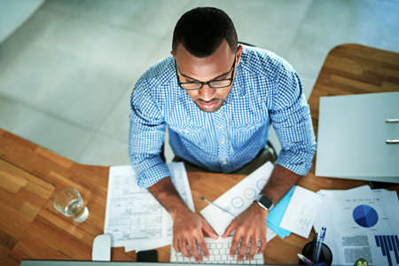 He has a strong work ethic. High angle shot of a handsome young businessman working in his office.