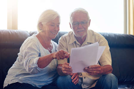 Managing their money as a team. a senior couple going through their paperwork together at home.の写真素材