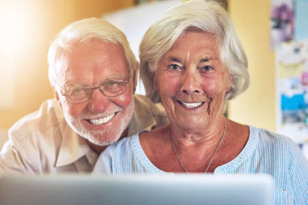 Quality time makes for a quality life. a senior couple using a laptop together at home.