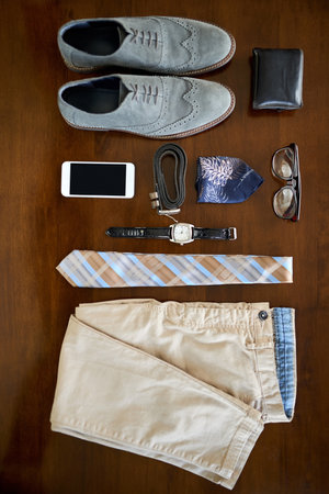 The modern executives essentials. High angle shot of a stylish business outfit and accessories laid out on a table.の写真素材