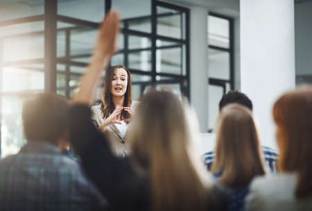Shell answer as many questions as possible. a young businesswoman fielding questions during a...