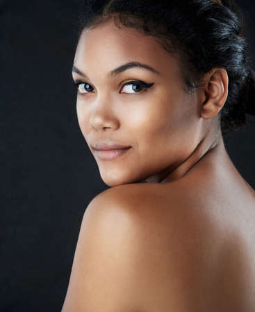Beauty is confidence applied directly to the face. a beautiful woman posing against a black...