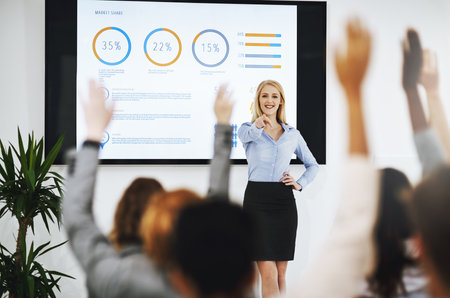 Raise your hands for learning opportunities. a group of unrecognizable businesspeople raising their hands to ask questions during a presentation.の写真素材