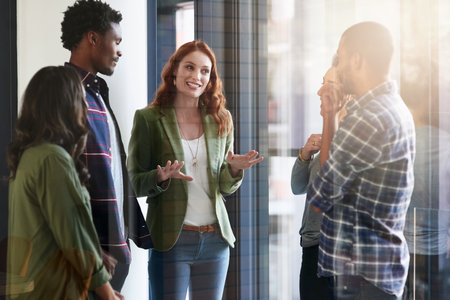 Shes leading the team to the top. a group of colleagues having an office meeting.の写真素材
