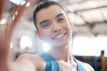 Sports, fitness and selfie with a woman in gym for training, exercise and health. Portrait of a young female athlete exercising and working out in a health club for wellness, sport and lifestyleの写真素材