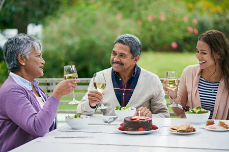 Many happy returns, my dear. a family enjoying a birthday lunch outside.