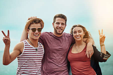Friends fill life with the most fun. Portrait of a group of friends spending time together outdoors.の写真素材