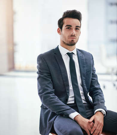 Confidently capable. Portrait of a serious young businessman posing in the office.の写真素材
