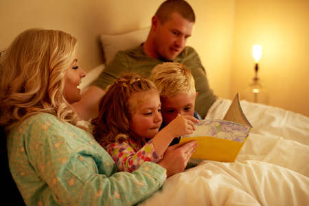 Bedtime is bonding time. a family reading a bedtime story together at home.の写真素材