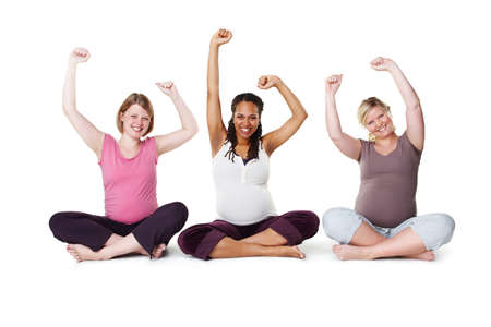 Pregnant, happy, and healthy, women sitting on the floor, arms raised in celebration of new life....