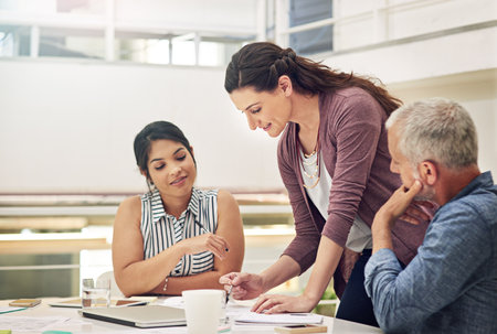 Shes fully prepared for their team meeting. a team of colleagues having a meeting in a modern...