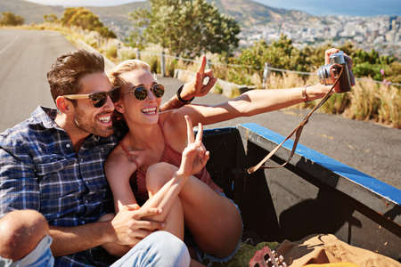 Taking nothing but memories back with them. a couple taking a selfie while out on a road trip.