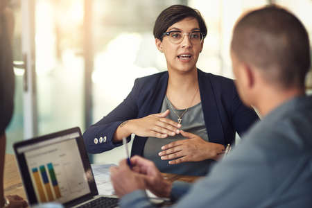 Giving her input. colleagues having a discussion in a boardroom.の写真素材