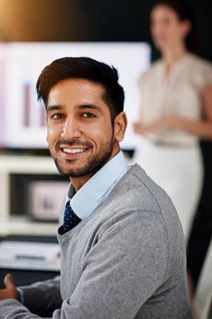 Hes a rising star in the company. Portrait of a young businessman sitting in a boardroom with...