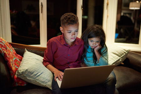 Are we over exposing our kids to technology. a young brother and sister using a laptop past their...