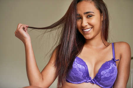 Shes a lover of lace. Portrait of a beautiful young woman in lingerie posing in her bedroom.