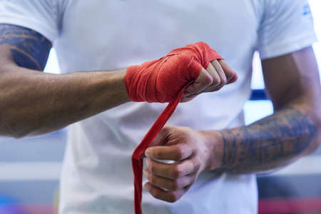 Lendinging strength to your hand during the punch. an unrecognizable man strapping his hands and...