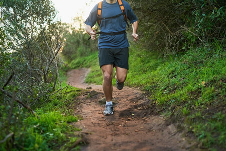 Hes making tracks. an unrecognizable male athlete running on a forest trail.