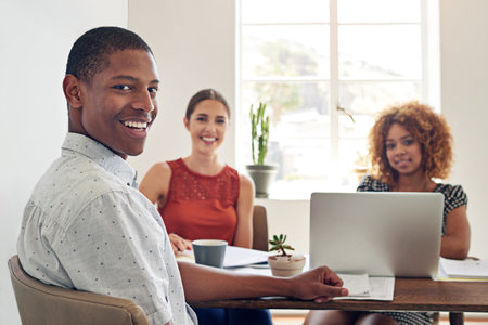Were a trifecta of skill. Portrait of a smiling young designer sitting in an office with colleagues...