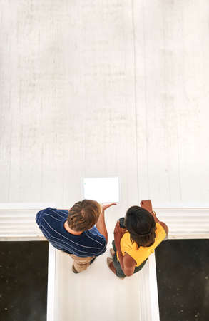 Take a look at this...High angle shot of two business colleagues standing together on a flight of...