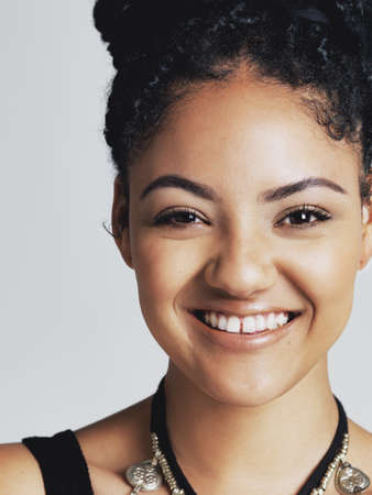 True happiness is true beauty. Studio portrait of a happy young woman posing against a grey...