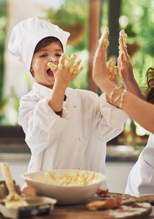 Joy in the kitchen. a mother and her young son baking together in the kitchen.の写真素材