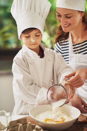 Homemade is the best. a mother and her young son baking together in the kitchen.