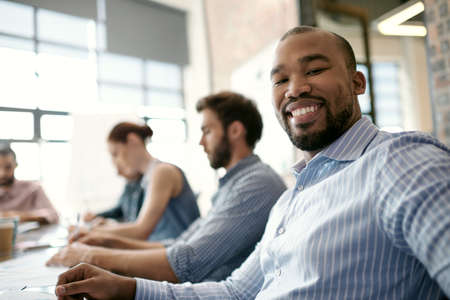 I really enjoy these meetings. Portrait of a handsome young businessman sitting in the boardroom during a meeting.の写真素材