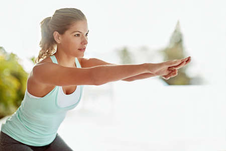 No workout is complete without some squats. a young woman doing squats during a workout.