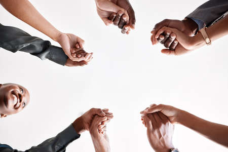 Diversity, support and collaboration of business people holding hands below in trust for company...