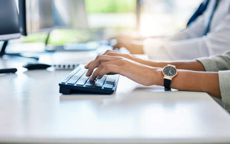 Hands, keyboard and typing with a business woman working on a computer at her desk in the office....