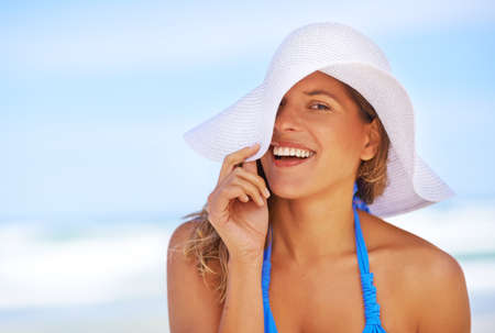Sunshine and smiles. a beautiful young woman at the beach.