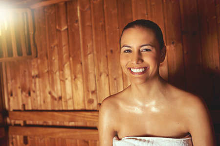 No stress today...Cropped portrait of a young woman relaxing in the sauna at a spa.の写真素材