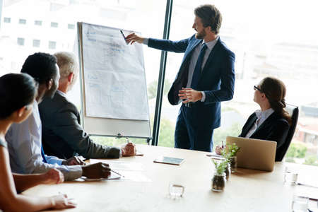 Charting the steps to success. a group of executives having a meeting in a boardroom.