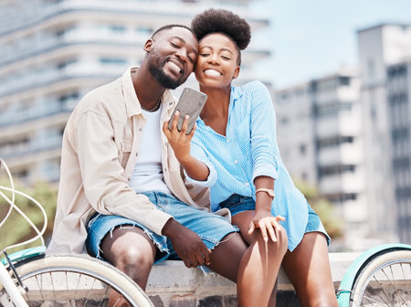 City travel, bicycle and selfie couple with smartphone on a date, vacation or summer holiday. Happy portrait man and woman or black people smile in photo for social media content or vlogging memoriesの写真素材