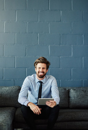 Positive about portability. Cropped portrait of a handsome young businessman using his digital...