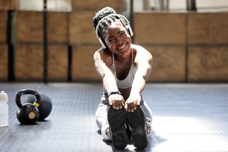 Portrait, black woman and stretching with headphones listening to music for fitness, health and...