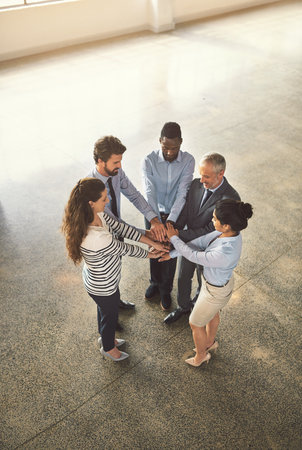 Meeting on the move. High angle shot of businesspeople standing in a office lobby.