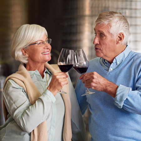 Cheers. an affectionate senior couple wine tasting in a cellar.