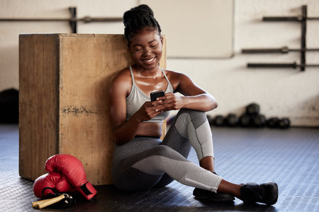 Phone, fitness and app with a black woman boxer tracking her workout, exercise and progress with a...