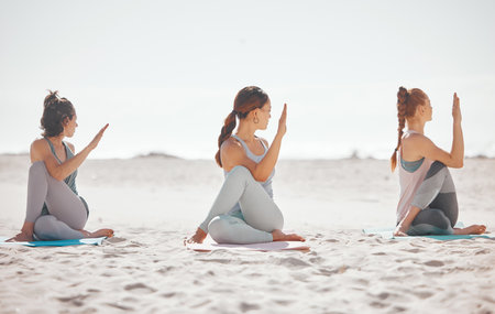 Zen, heath and yoga group meditation on a beach with women training and meditating together. Athletic friends exercise, practice posture and balance yoga pose with zen, peaceful energy in natureの写真素材