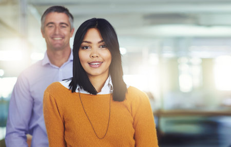 Well get the job done. Cropped portrait of two coworkers standing in the office.の写真素材