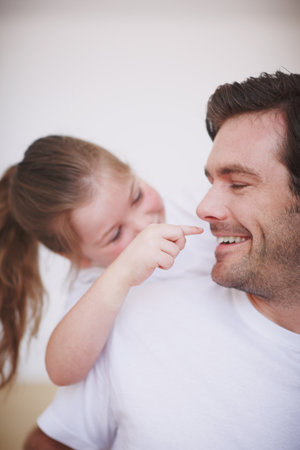 Always playful and affectionate. A little girl being playful and affectionate towards her dad.の写真素材