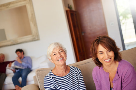 Spending some time with mom. Portrait of a senior woman sitting beside her daughter at home.の写真素材
